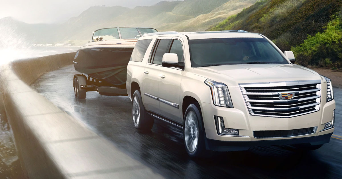 2019 Cadillac Escalade towing a boat on a winding road