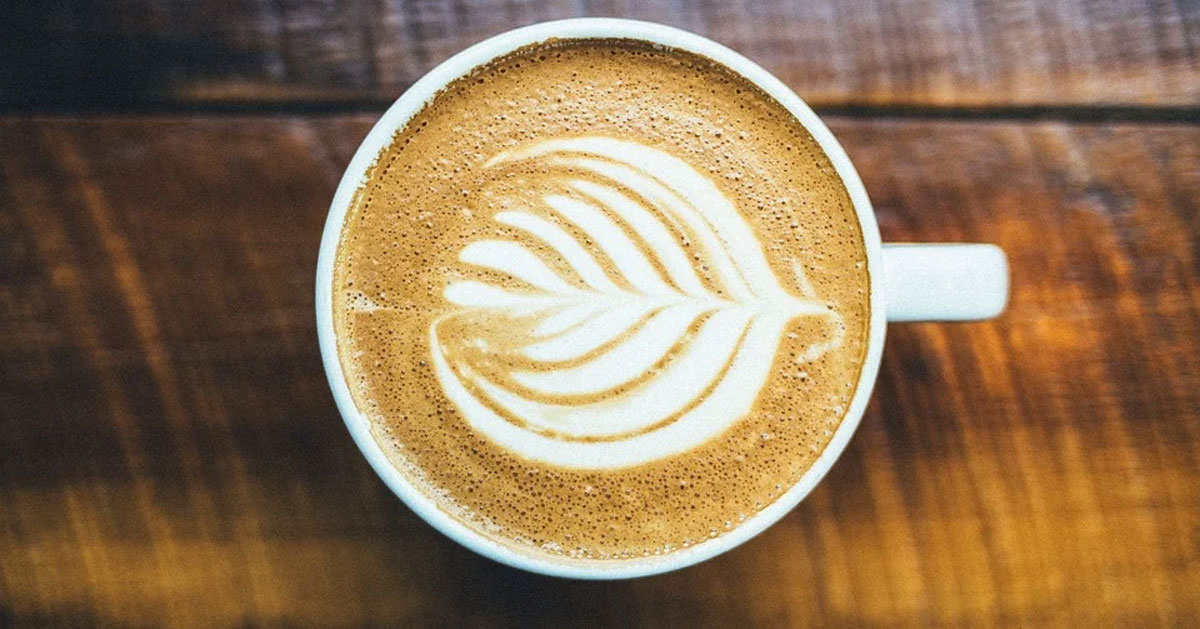 A latte with a leaf design in the frothed milk