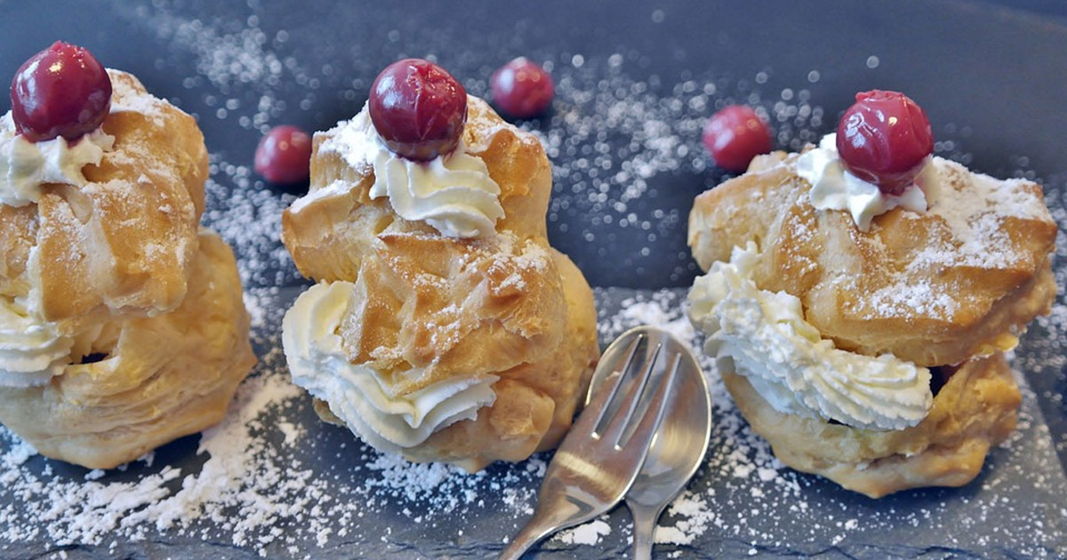 Puff pastries with whip cream and cherries