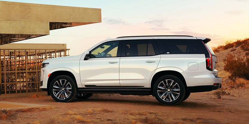2021 Cadillac Escalade in white parked in front of a modern looking house