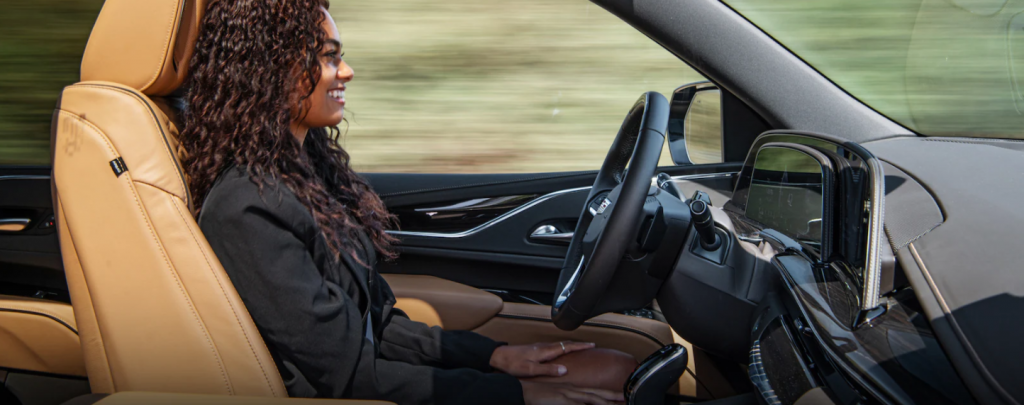 a women in a 2021 Cadillac Escalade with her hands off the wheel using the Duper Cruise feature.